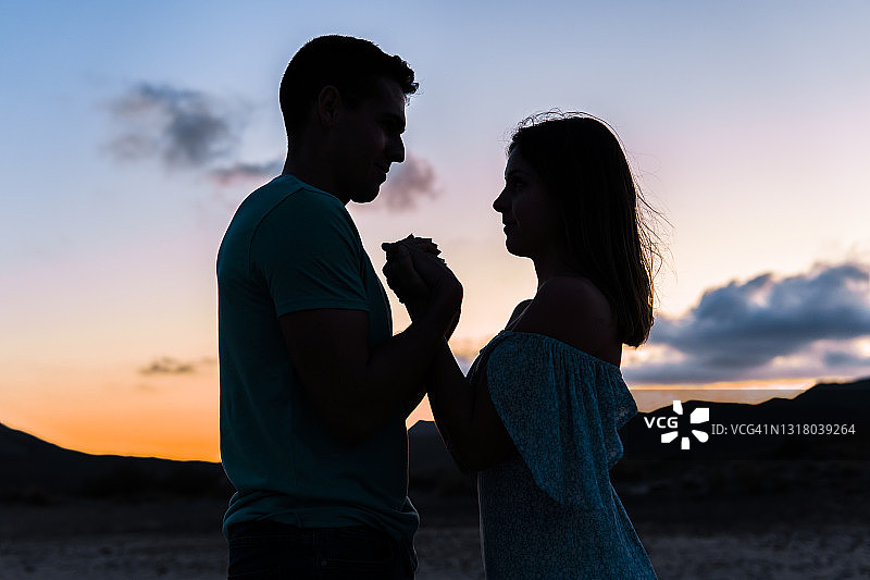 日落时分，情侣在户外牵手图片素材