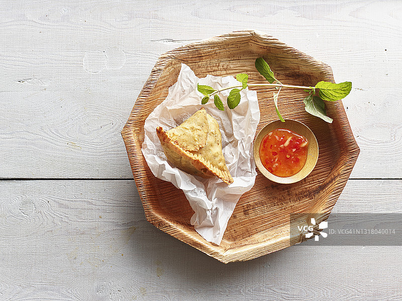 木制杯垫上的咖喱角和辣椒酱图片素材