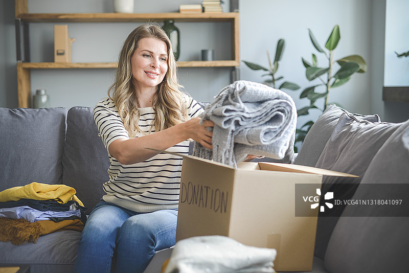 女人往箱子里捐款图片素材