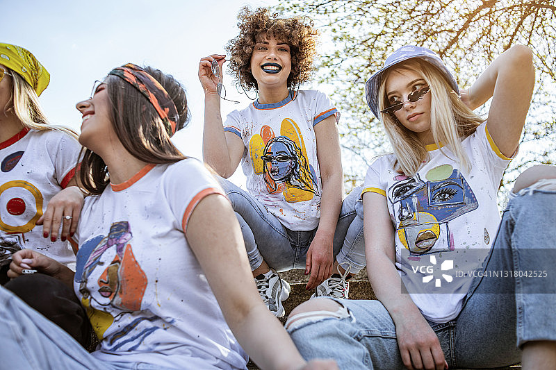 现代年轻女孩在篮球场上消磨时光，坐在看台上享受美丽的晴天图片素材