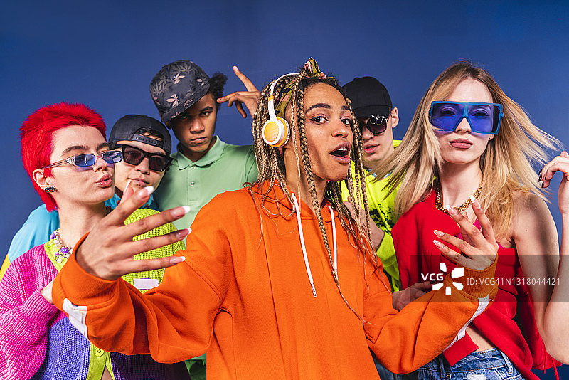 朋友们在蓝色背景前一起跳舞图片素材