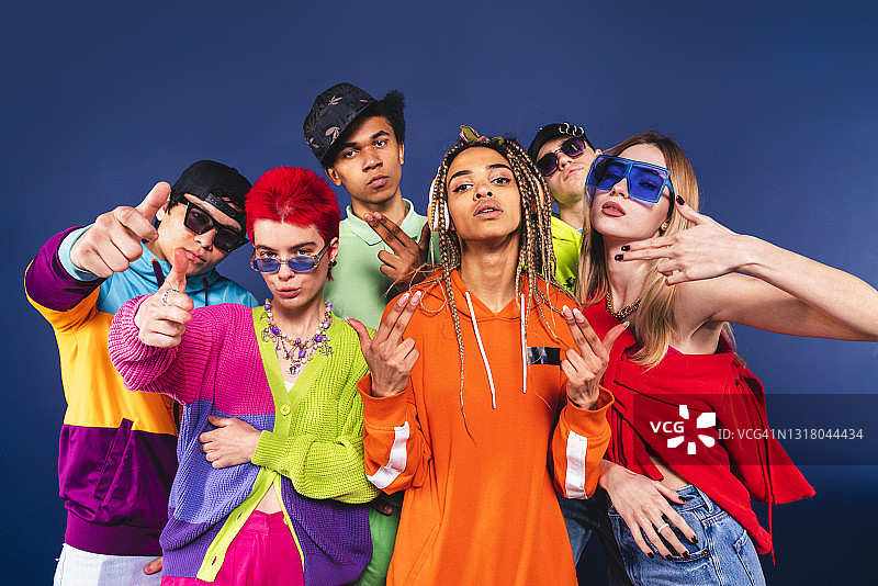 站在蓝色背景前做手势的男女朋友图片素材