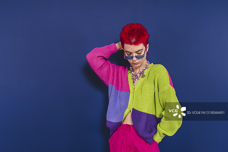 年轻女子站在蓝色背景前图片素材