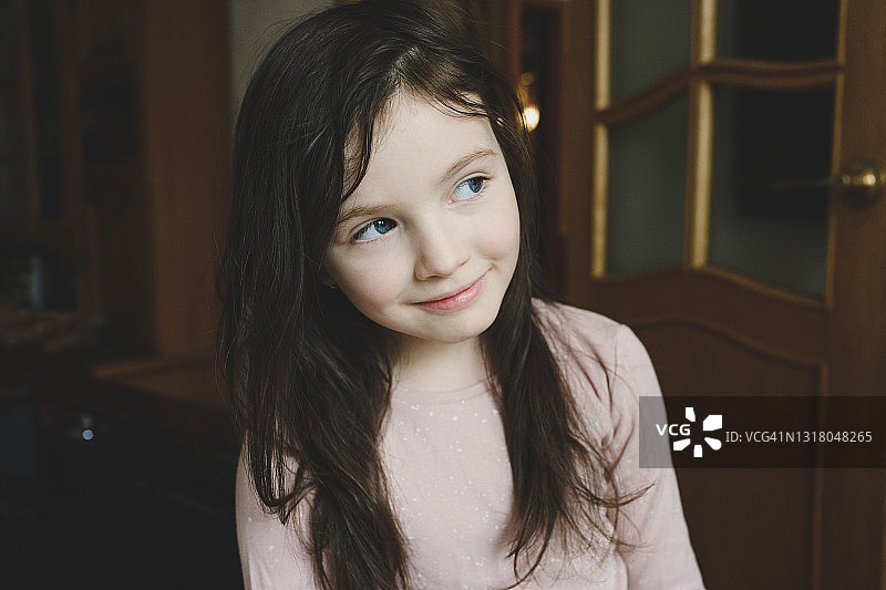 在家好奇地向远处看的蓝眼睛女孩图片素材