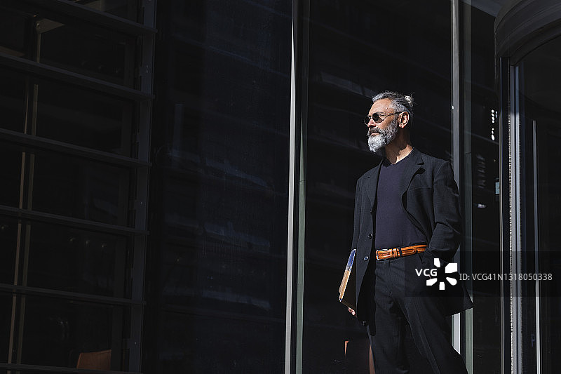 在城市里手插口袋眺望远方的商人图片素材