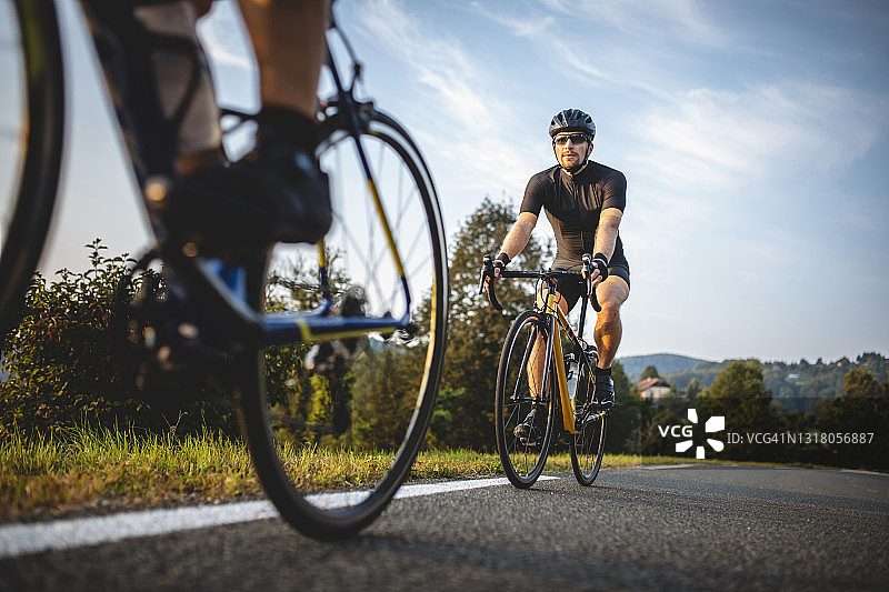 中年男子骑自行车者在早晨攀登山路图片素材