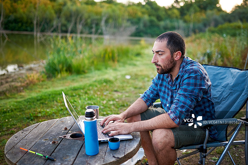 一个人在露营时使用笔记本电脑图片素材