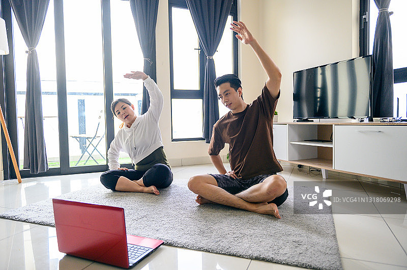 亚洲夫妇使用数码设备参加在线健身课程图片素材
