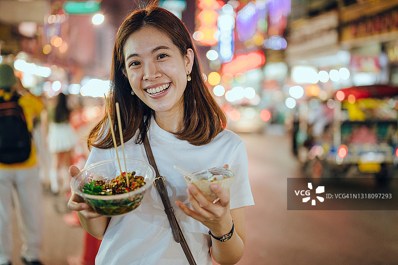 顾客在泰国曼谷街头享用美食的肖像图片素材