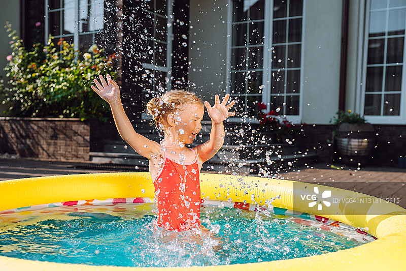 夏日小女孩在家附近充气泳池玩水图片素材