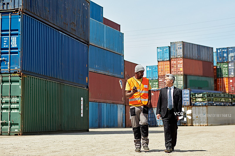 配送主管和货物搬运工在户外行走图片素材