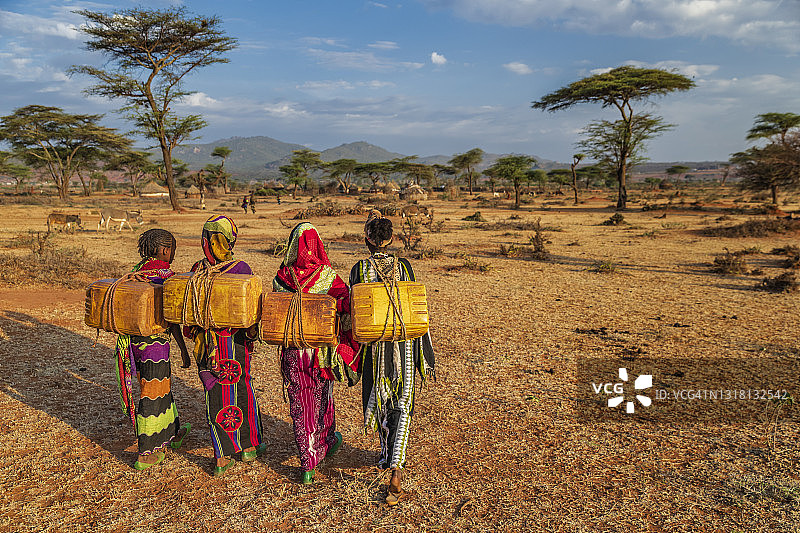 在埃塞俄比亚从井里取水的年轻非洲妇女图片素材
