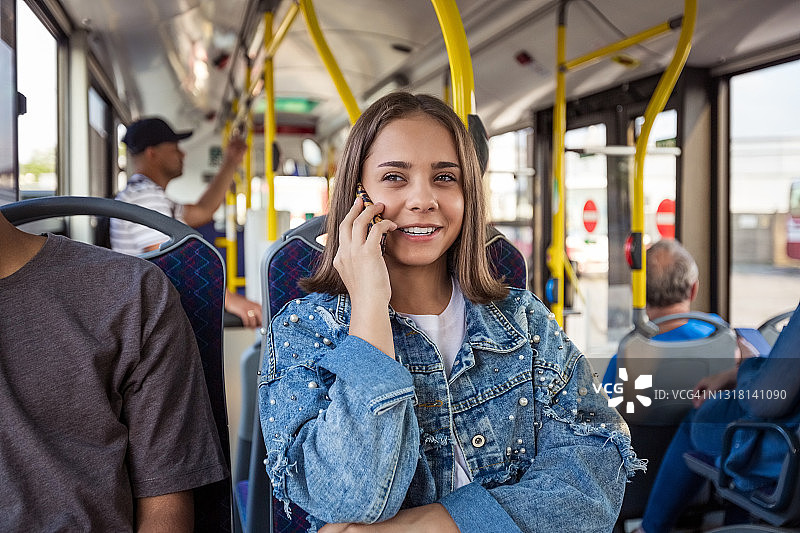 在公交车上用手机通话的女孩图片素材