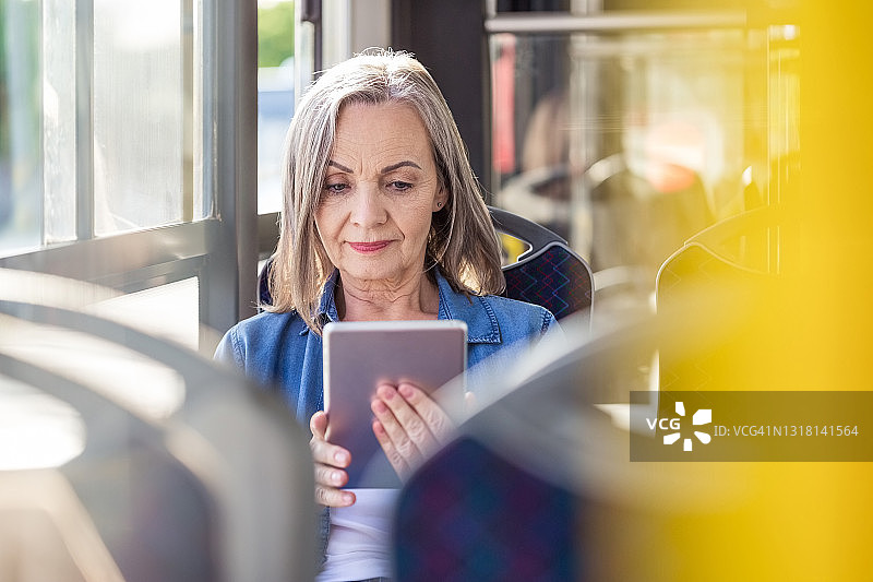 在公交车上使用平板电脑的女人图片素材