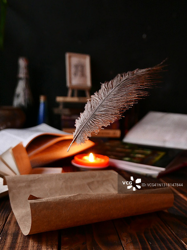 悬浮的羽毛和莎草纸卷轴，木桌上的旧书，魔法氛围图片素材