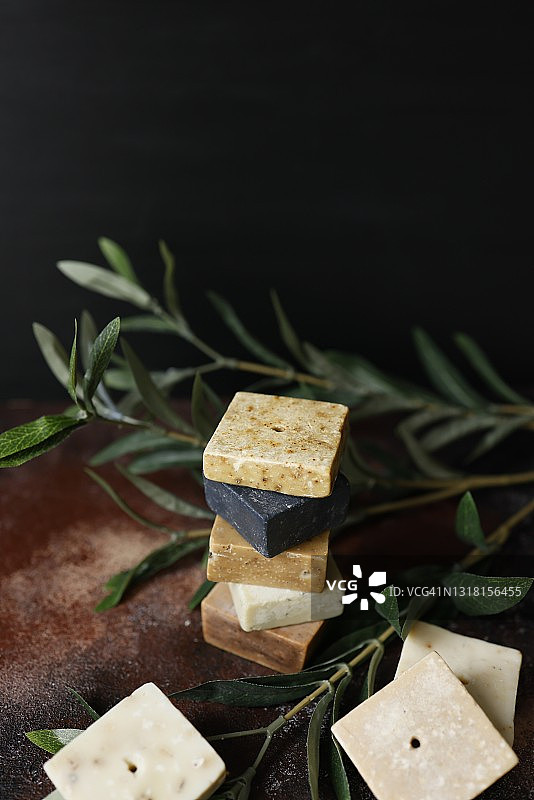 乡村风格的手工小方草药皂，黑色背景图片素材