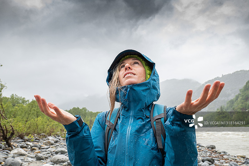 女徒步者在暴雨中仰望图片素材