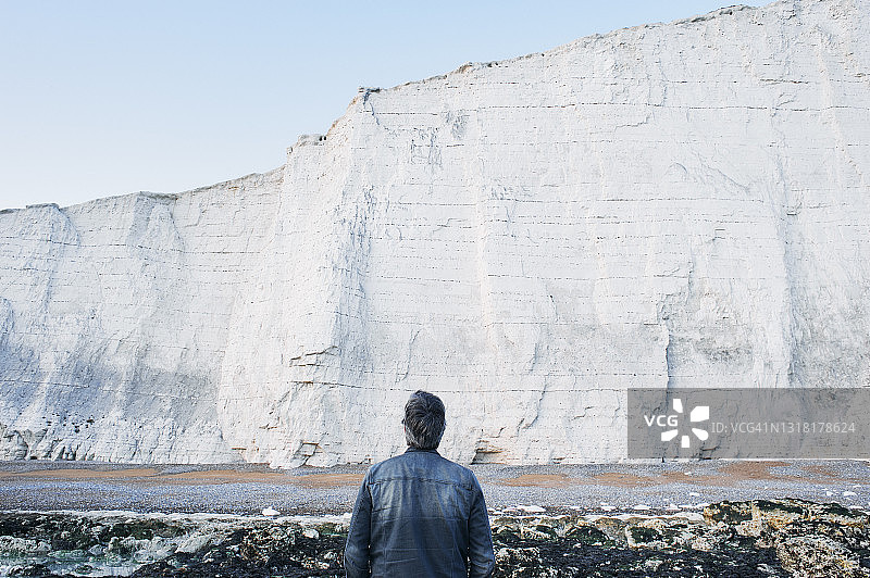 男人抬头看着白垩悬崖图片素材