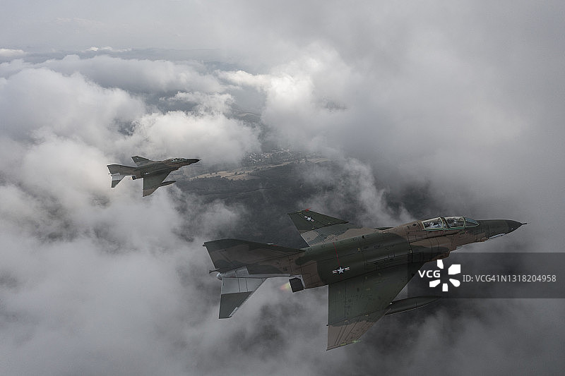 喷气式战斗机飞过云层。图片素材
