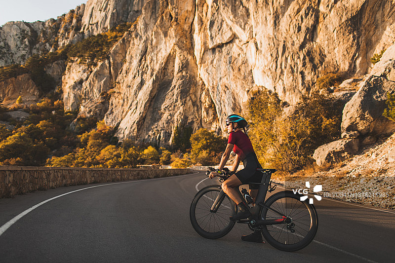公路自行车上的自行车女运动员肖像图片素材