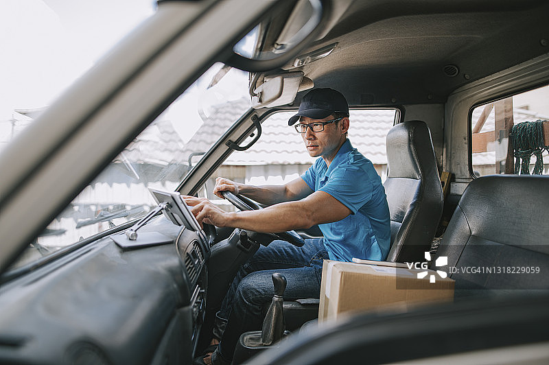 中国送货员在送货车上用平板电脑查看送货信息图片素材