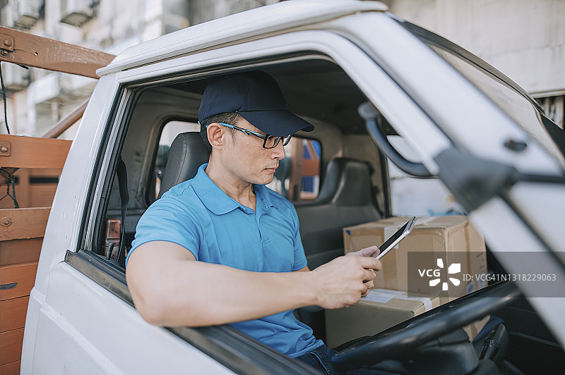 中国送货员在送货车上用平板电脑查看送货信息图片素材
