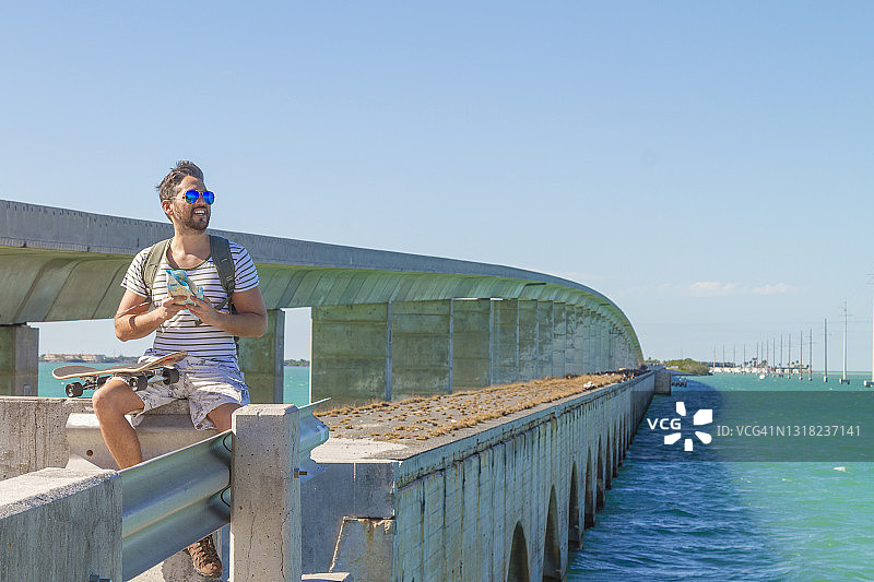 年轻滑板手在佛罗里达州基韦斯特旅行并查看地图图片素材