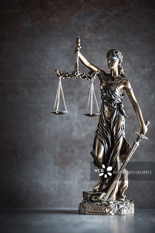 黑暗背景下象征法律和秩序的正义女神蒙眼雕像细节图片素材