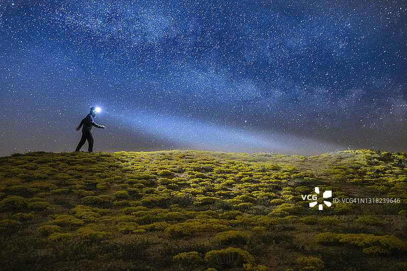 凝视星星冥想，广阔的夜间高山岩石景观，地平线上壮丽的银河星空，灵感和精神，心理健康图片素材
