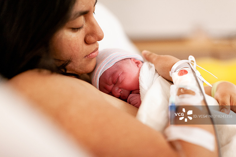 母亲在医院产房抱着新生婴儿图片素材