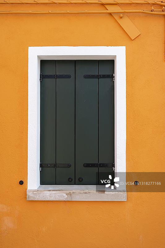 带窗户的橙色墙壁，彩色房屋墙壁，关闭的百叶窗，彩色外墙，布拉诺岛，威尼斯，威尼托，意大利图片素材