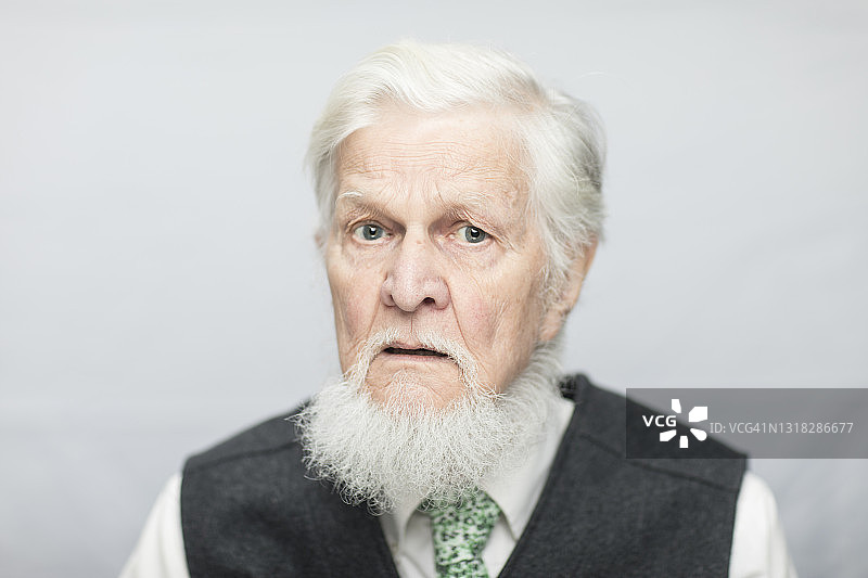 白色背景前的严肃老年男人肖像图片素材