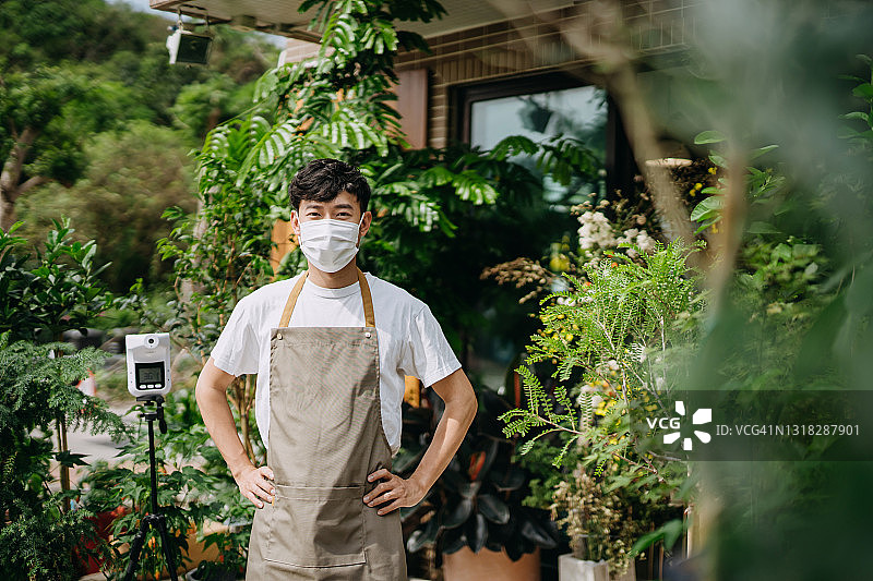 佩戴口罩防止新冠病毒传播的亚洲花店主肖像：疫情后重新营业图片素材