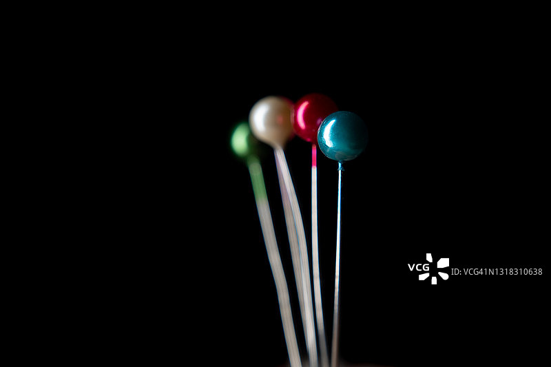 黑色背景上的彩色缝纫针图片素材