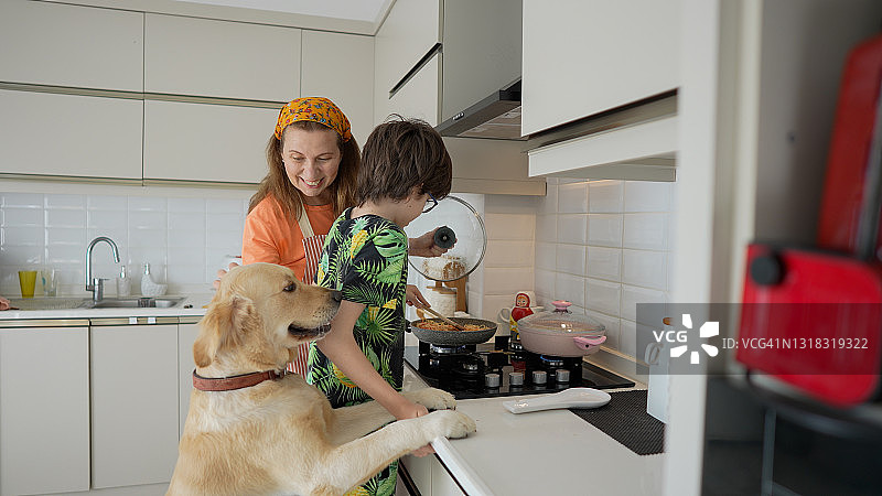 妈妈和儿子在厨房里和狗狗一起做意大利面图片素材