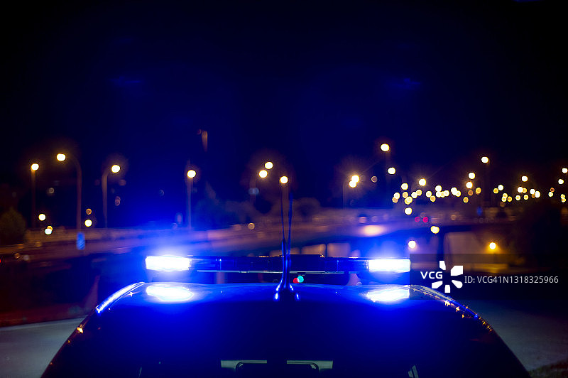 背景是城市且带有明亮警笛的警车图片素材
