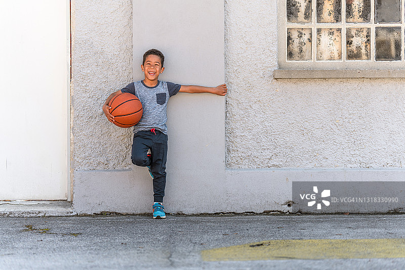 手拿篮球的可爱混血儿童图片素材