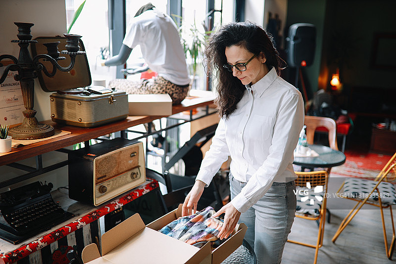 小型时装店的女店主打包衣服图片素材