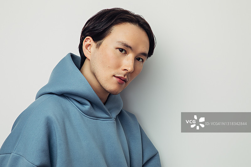 戴帽衫的亚洲男人表达情感图片素材