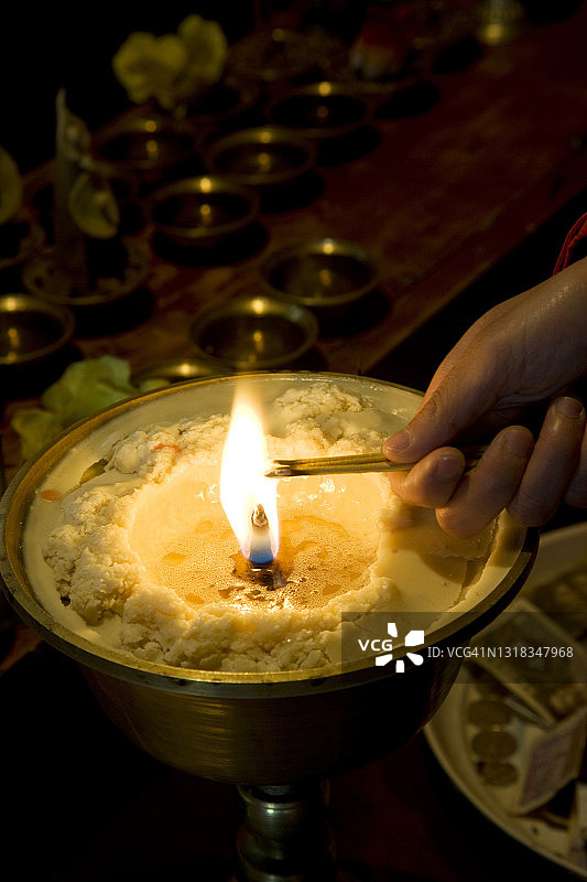女子在佛教寺庙点燃香图片素材
