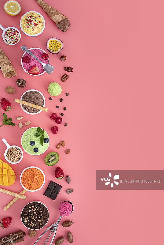 一排什锦冰淇淋杯和粉红色背景上的彩色华夫饼锥图片素材