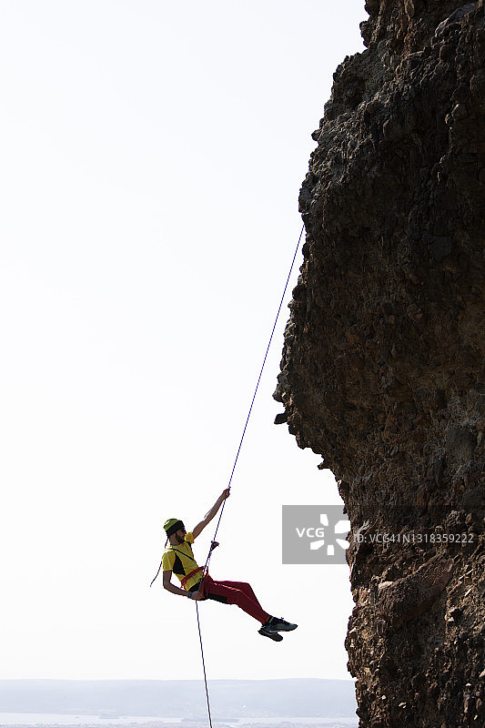 史诗般的冒险极限运动：攀岩男子速降图片素材
