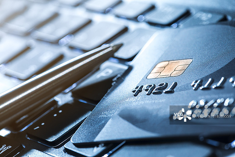 信用卡和圆珠笔在笔记本电脑上图片素材