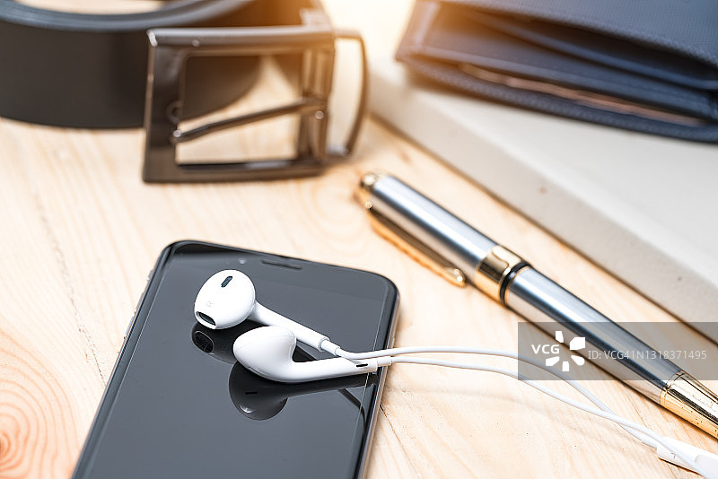 手机耳机黑色屏幕木桌背景图片素材