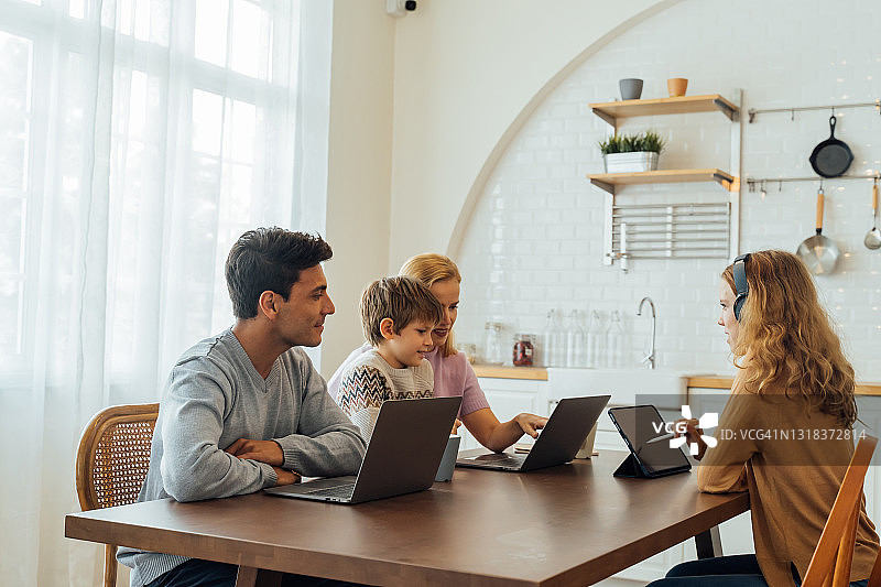 在家中使用电子设备的年轻家庭图片素材