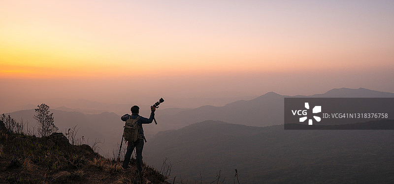 摄影师在山顶庆祝成功图片素材