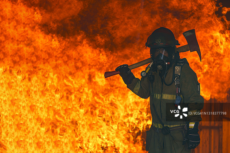 消防员手持铁斧在火灾现场救援图片素材