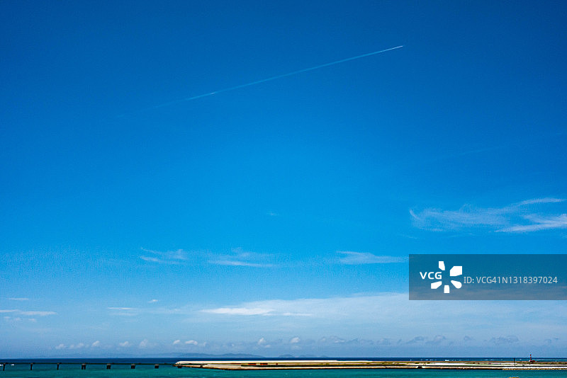 飞机在日本那霸市海滩上空飞行图片素材