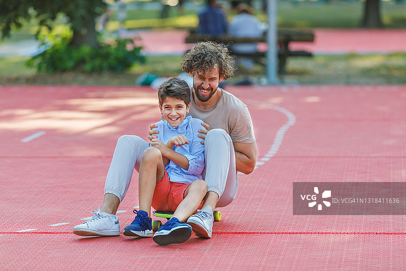 父亲儿子自然中玩滑板图片素材