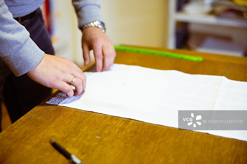 在桌子上铺白色帆布进行刺绣图片素材